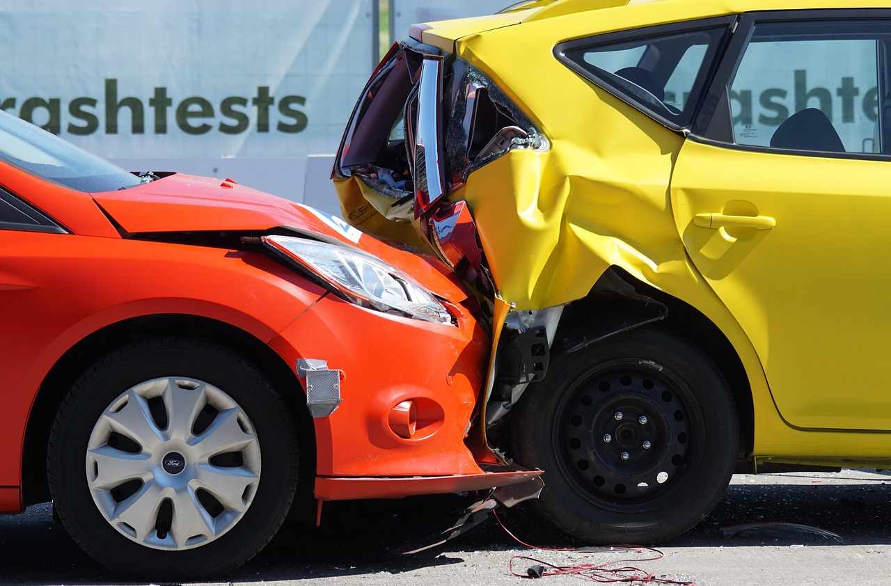 An orange car rear-ending a yellow vehicle, illustrating a severe collision commonly handled by our Burbank rideshare accident lawyer.