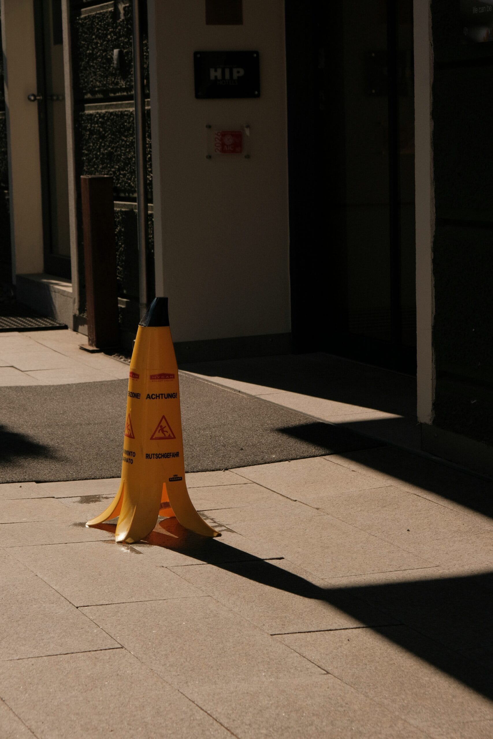 Yellow caution wet floor sign next to a spilled liquid, highlighting property owner negligence in a personal injury lawsuit.
