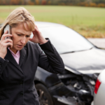 Woman on the phone near a damaged vehicle after a car accident in Burbank